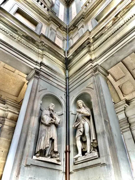 Photo of galileo galilei (1564-1642) & pier antonio micheli (1679-1737) - are life size marble sculptures housed in two of 28 niches of the colonnade of the uffizi gallery in florence, tuscany, italy.