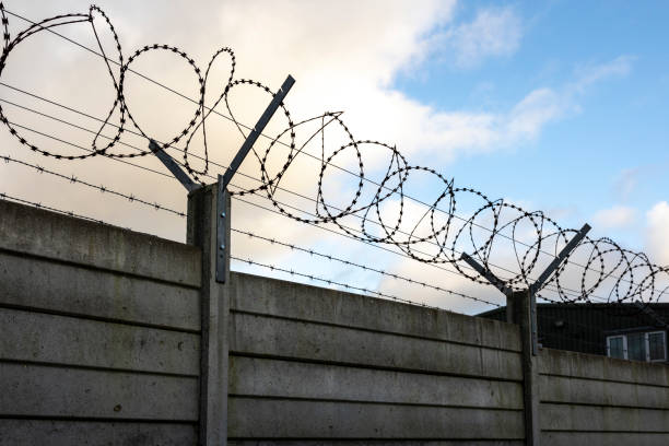 razor wire and blue sky - razor wire imagens e fotografias de stock