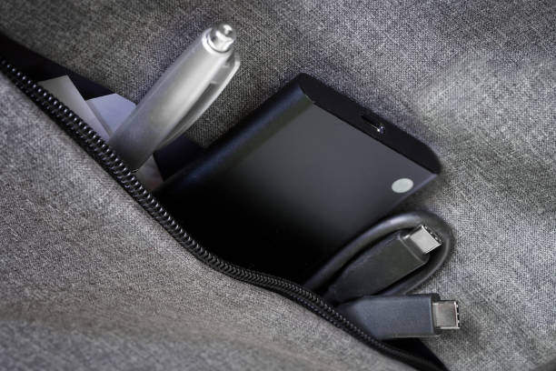 istock Small External portable SSD sits in a bag or jacket pocket next to a pen and USB type-c cable. Solid State Drive. The concept of modern technologies, gadgets and the use of an SSD disk 1367546901