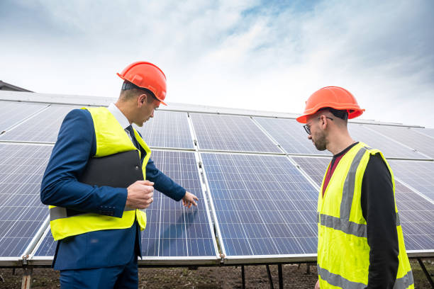istock young worker in overalls with boss in overalls looking at newly installed solar panels. 1367548547