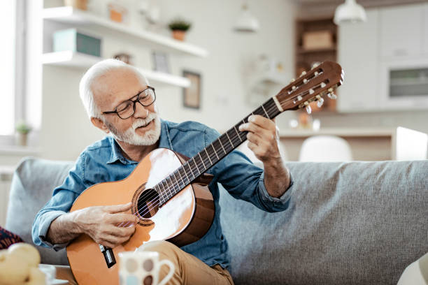 bearded senior man with acoustic instrumental guitar - guitarist one person caucasian adult imagens e fotografias de stock