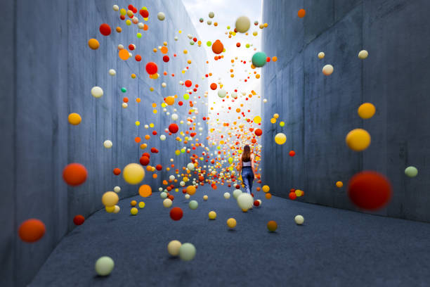 woman walking in abstract concrete corridor - color balls imagens e fotografias de stock