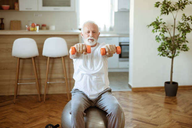 istock Senior Man Doing Exercises With Dumbbells at Home 1367550995