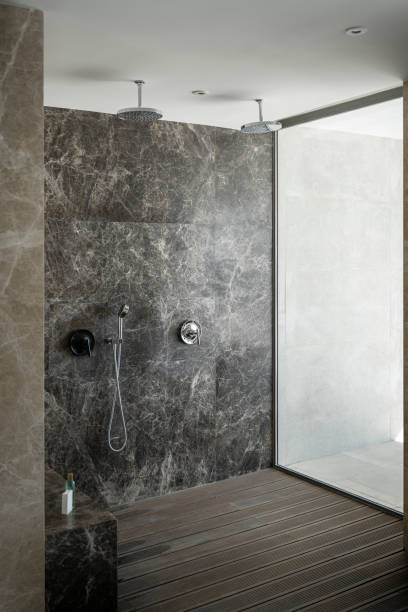 istock Modern twins shower, black marble bathroom whit wooden floor, vertical image 1367552059