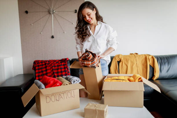 istock Woman sorting clothing and packing donation box 1367553033