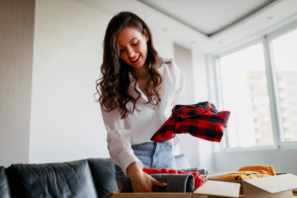 istock Woman sorting clothing and packing donation box 1367553094