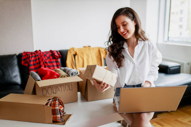 istock Woman sorting clothing and packing donation box 1367556414