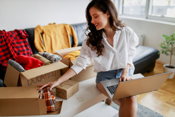 istock Woman sorting clothing and packing donation box 1367556450