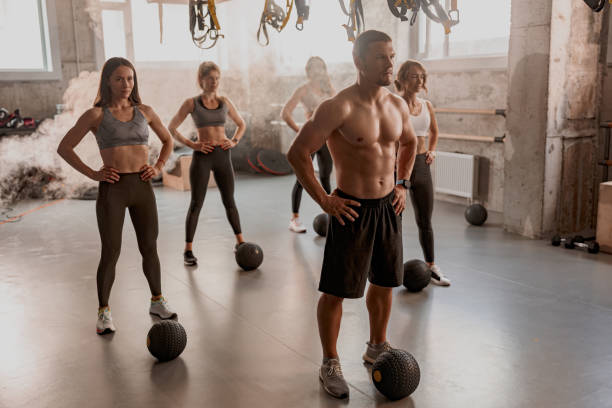 istock Group of people exercising with ball at gym 1367559166