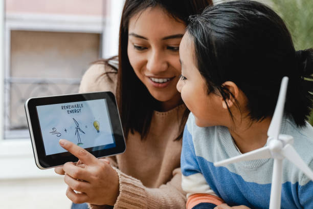 asiatisches kind lernt in der kindergartenklasse etwas über alternative erneuerbare energien - lehrer hält tablet im fokus - indian child stock-fotos und bilder