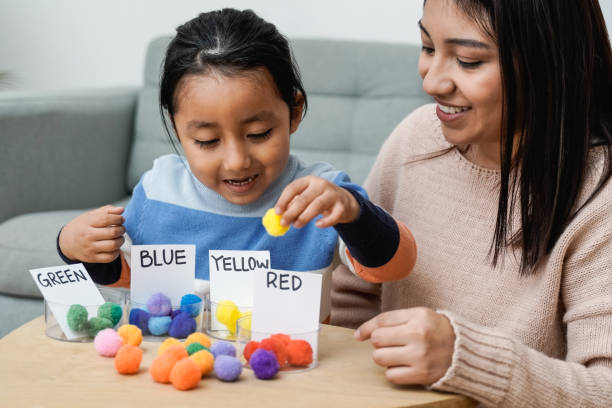 Asian kid playing didactic game with his mom at home - Montessori education concept - Focus on mother face Asian kid playing didactic game with his mom at home - Montessori education concept - Focus on mother face iberian ethnicity stock pictures, royalty-free photos & images