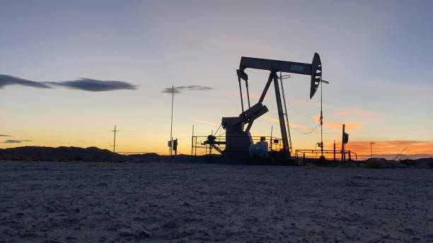 piattaforma di fracking per perforazione di petrolio o gas mentre il sole sorge nel new mexico - gas oil oil rig nature foto e immagini stock