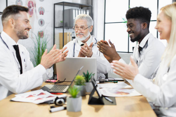 istock Multiethnic doctors clapping in hands during meeting 1367562390