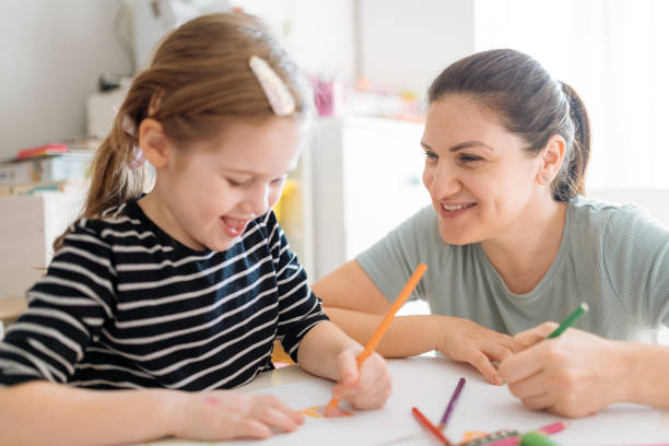 istock Mother and daughters playing, drawing and laughing 1367563209