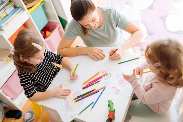 istock Mother and daughters playing, drawing and laughing 1367563218