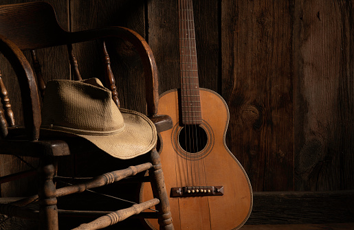 Wild West theme with barnwood, acoustic guitar, saloon chair and cowboy hat. Subdued lighting for good print separation