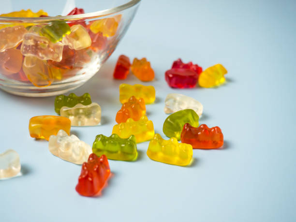 istock Bowl with tasty bright gummy bears on blue table 1367569373
