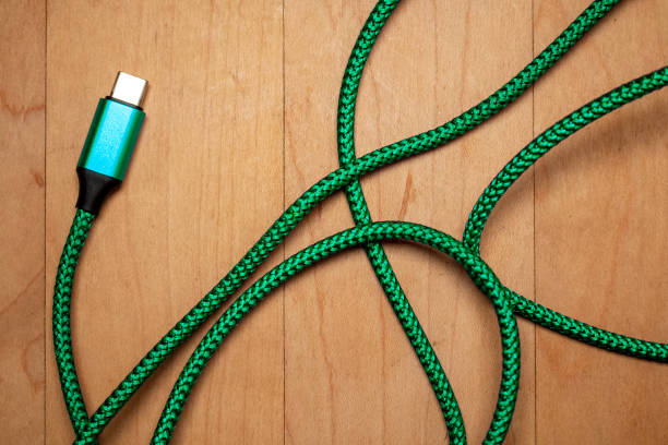 a green usb-c type wire cord electronic data files external cable connection wood tech desk backdrop