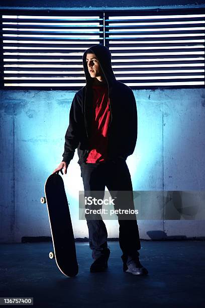 Foto de Adolescente Com Um Skate No Fundo Azul Escuro e mais fotos de stock de Noite - Noite, Skate, Adolescente