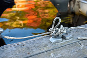 Rope knotted to a cleat in lakeside marina