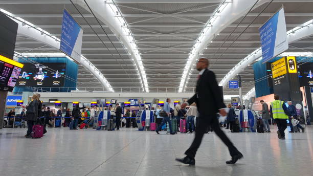 Airport Departures Hall London, UK - April 15, 2018: Air travelers check into flights at Heathrow Airport's terminal 5 departures hall. Heathrow is one of the world's busiest airports and first in Europe by passenger volume. heathrow airport stock pictures, royalty-free photos & images