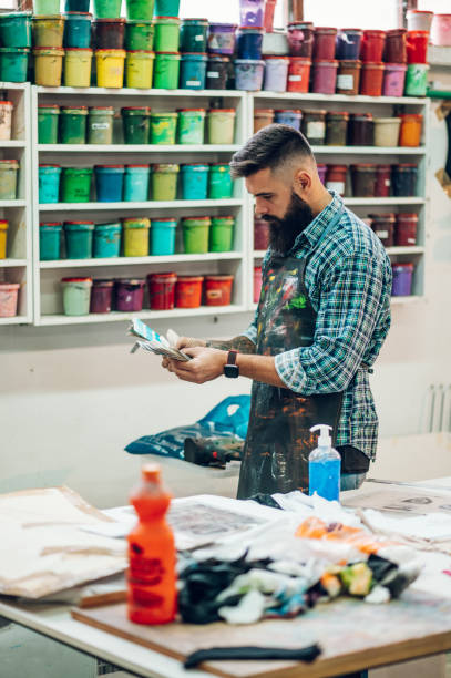 istock Male worker mixing colors for screen printing in a workshop 1367581593