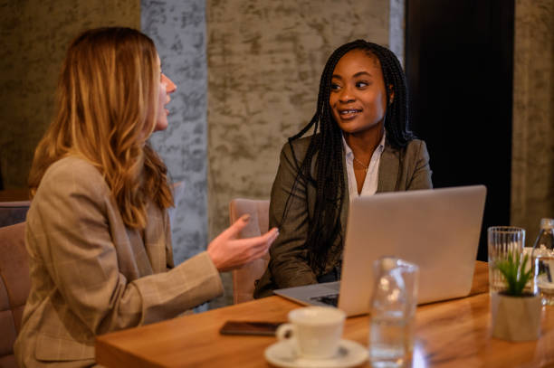 istock Two businesswoman having a meeting in a cafe while using a laptop 1367581618