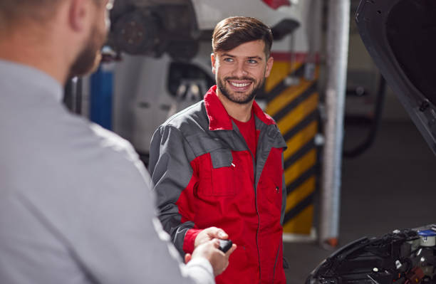 istock Male mechanic taking keys from client 1367581809