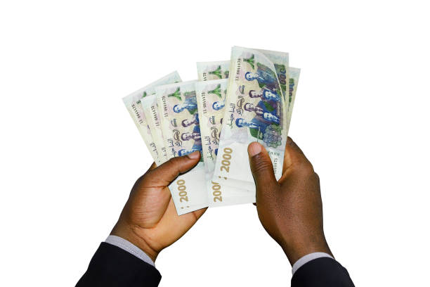 istock Black Hands in suit holding 3D 2000 Algerian Dinar notes 1367588250