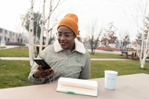 istock Girl holding a phone and a reusable coffee cup 1367588719