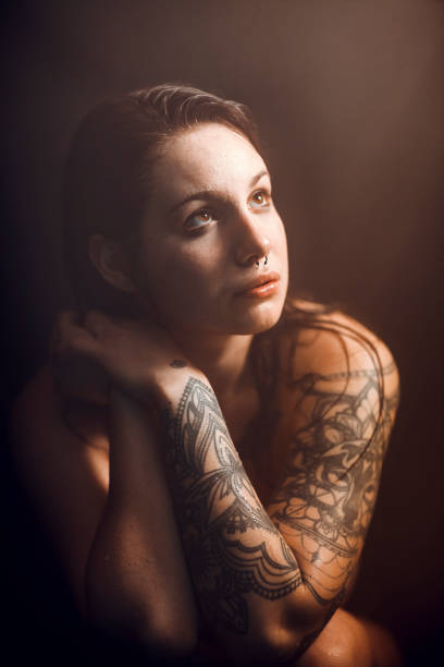 istock Tattooed woman taking bath in dark bathroom 1367590358