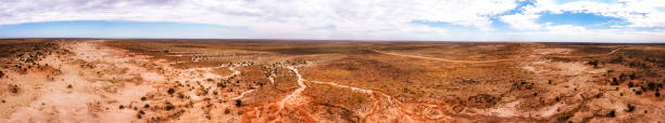 D Mungo over walls low pan Walls of china in dry empty Mungo lake of Australian outback - wide aerial panorama of landscape. lakebed stock pictures, royalty-free photos & images