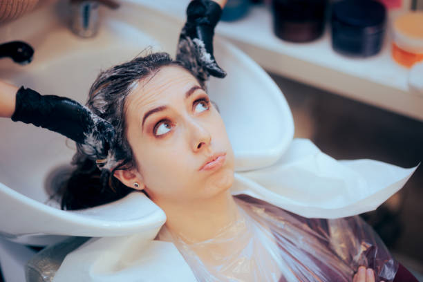 Worried Woman Having her Hair Washed by the Hairdresser Stressed customer feeling a neck pain while sitting by the sink basin angry hairstylist stock pictures, royalty-free photos & images