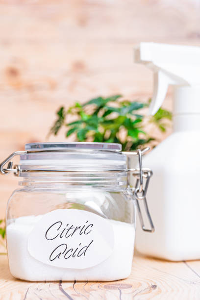 istock Citric acid in container on wooden background. 1367596843