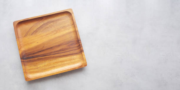 istock Empty wooden plate on gray cement table background, banner with copy space, Blank wood tray for food display montage, template, mock up, top view, flat lay 1367602583