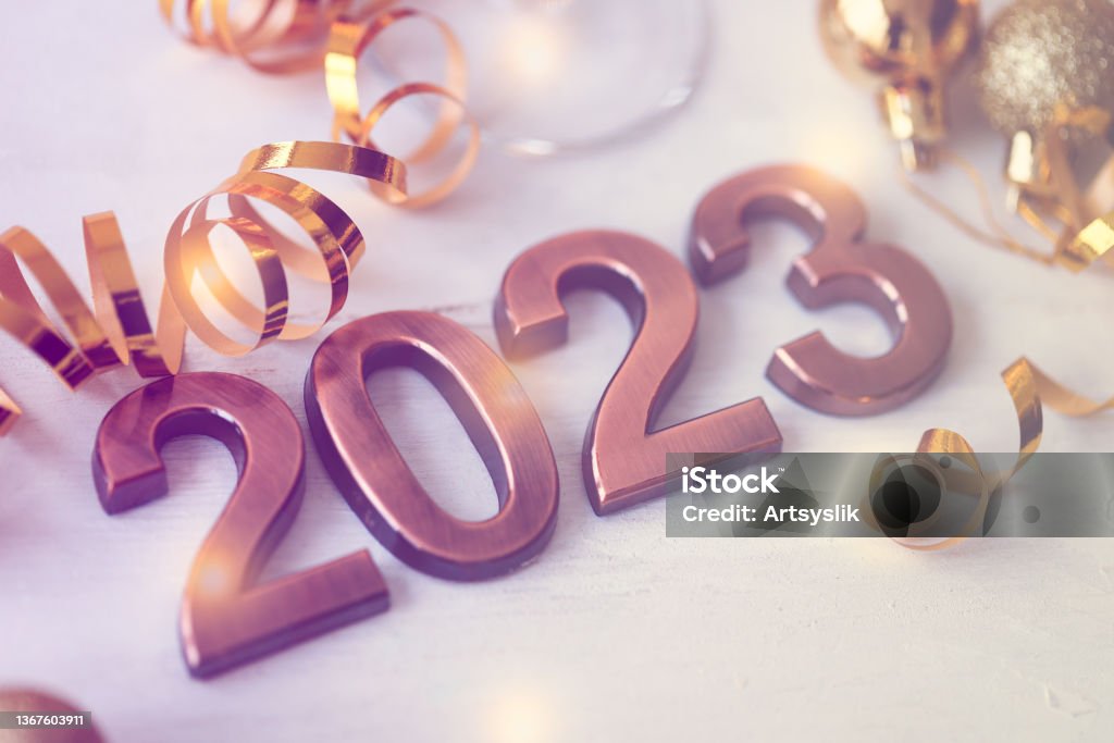 New 2023 year. Greeting card. Golden holiday decor, metal digits. Christmas lights on background. Bokeh. Copy space for text 2023 Stock Photo