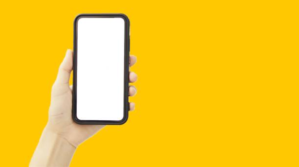 istock Hand holding smartphone on yellow background 1367604524