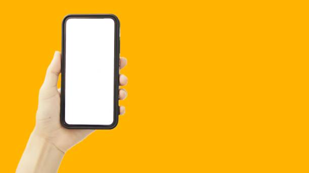 istock Hand holding black smartphone isolated on yellow background 1367604565