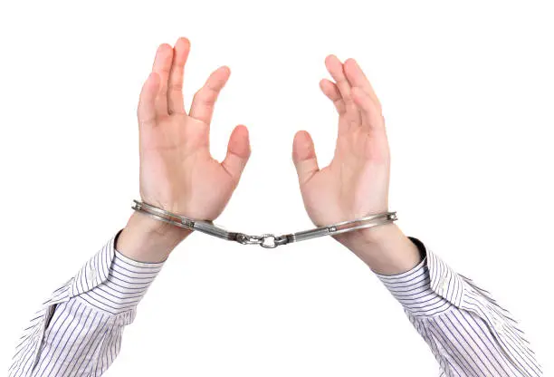 Handcuffs on Hands closeup Isolated on the White Background