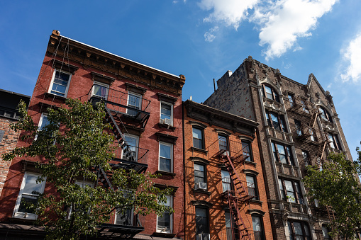 istock Row of Colorful Old Brick Apartment Buildings with Fire Escapes in Williamsburg Brooklyn of New York City 1367607801