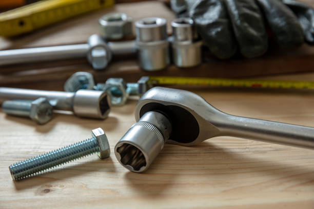 Torque wrench, work tool on wooden background. Hand tool for screw and nut tighten. Torque wrench, work tool with reversible ratchets on wooden background. Hand tool for screw and nut tighten. Workshop table, closeup view bolt fastener photos stock pictures, royalty-free photos & images