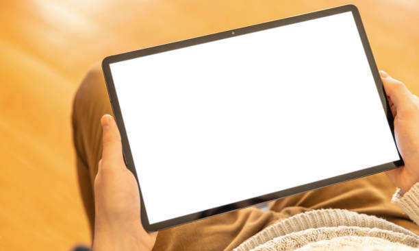 istock Blank digital tablet screen. Man work at home office, hold device on leg, white empty display 1367614590