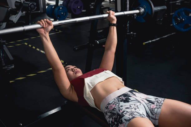 istock A fit and athletic asian woman does flat barbell bench presses. Chest workout session. 1367618845