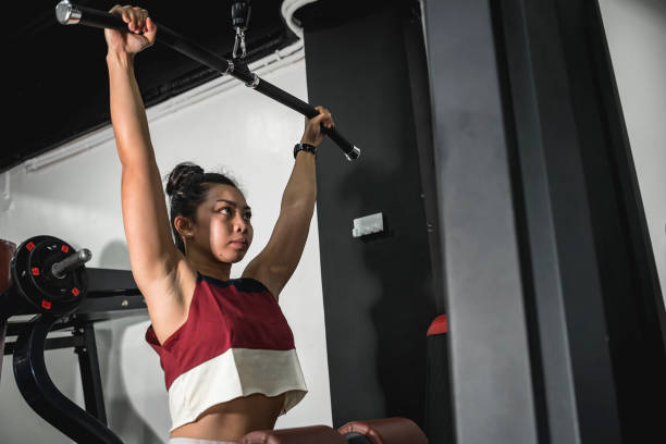 istock An athletic asian lady working out, using the lat pulldown cable machine at the gym. 1367618915