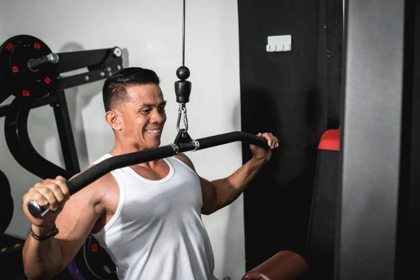 istock A asian man in a white tank top working out, training back muscles. Intense workout concept. 1367618968