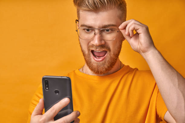 istock Shocked man with red beard keeps jaw dropped, received message on phone 1367619004