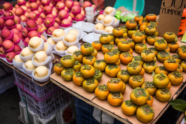 Apples, peaches and persimmons for sale at a street market in Divisioria, Manila, Philippines Apples, peaches and persimmons for sale at a street market in Divisioria, Manila, Philippines divisoria market stock pictures, royalty-free photos & images