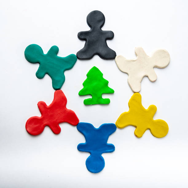 multicolored bright plasticine men in a circle in the center of a green tree isolated on a white background. eco-friendly concept - childs play clay small men team imagens e fotografias de stock