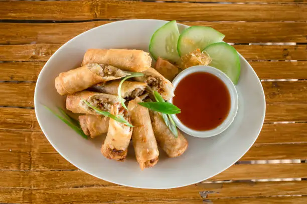 Top view of Lumpiang Shanghai, A filipino deep-fried spring roll served with sweet and sour sauce.