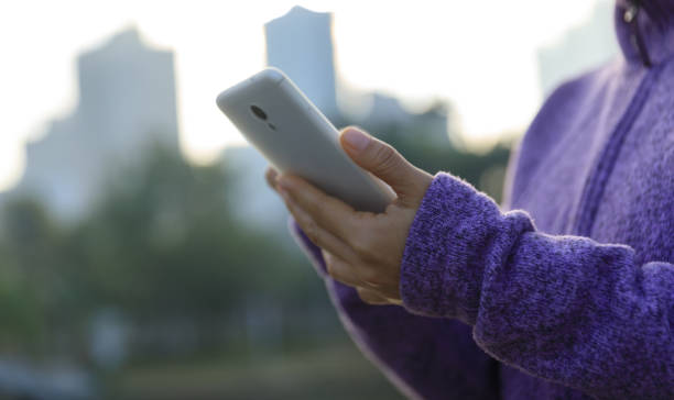 istock Woman using cellphone in city 1367630448